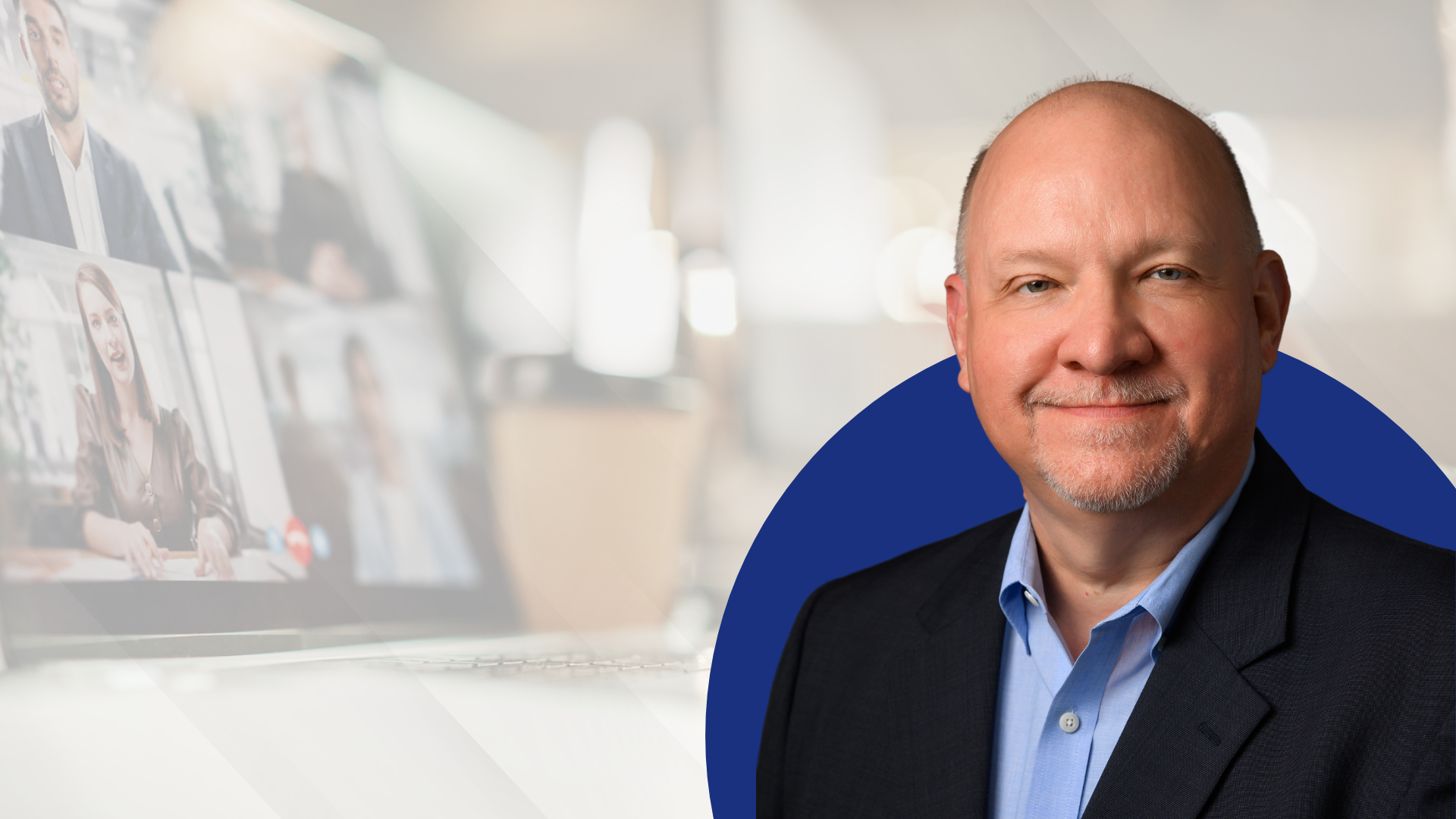 Here's alt text for this image: Short version: "John Fentress, headshot photo against a blurred office background with a video conference screen visible